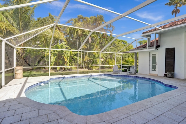 swimming pool featuring a patio area and glass enclosure