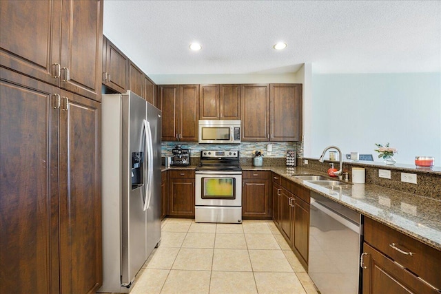 4738 Sundance Way, Davie, FL 33328 - kitchen with light tile patterned flooring, a sink, dark stone counters, stainless steel appliances, and decorative backsplash
