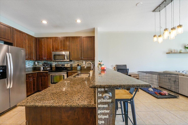 4738 Sundance Way, Davie, FL 33328 - kitchen with decorative backsplash, a kitchen bar, a sink, a peninsula, and stainless steel appliances