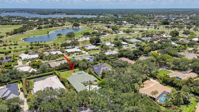 aerial view of property and surrounding area featuring nearby suburban area, a nearby body of water, and a golf club