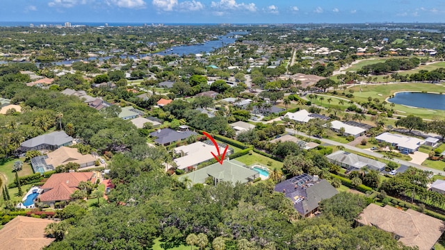 aerial overview of property's location featuring a nearby body of water, nearby suburban area, and a golf course