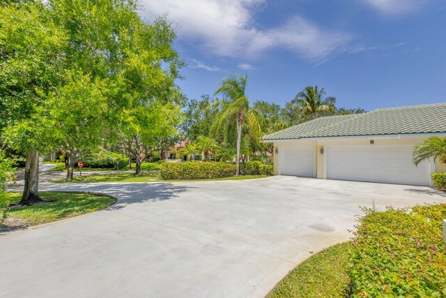view of home's exterior featuring concrete driveway, a tile roof, and stucco siding