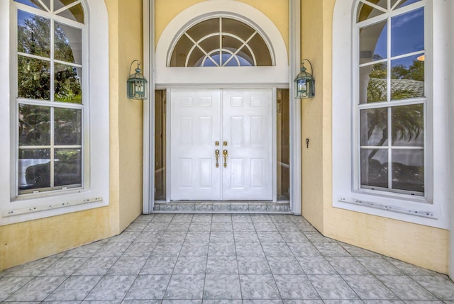 entrance to property with stucco siding and a porch
