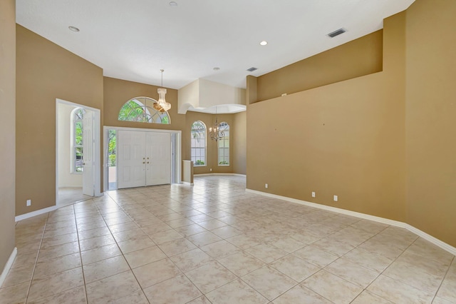 foyer entrance with a chandelier, light tile patterned floors, a high ceiling, baseboards, and recessed lighting