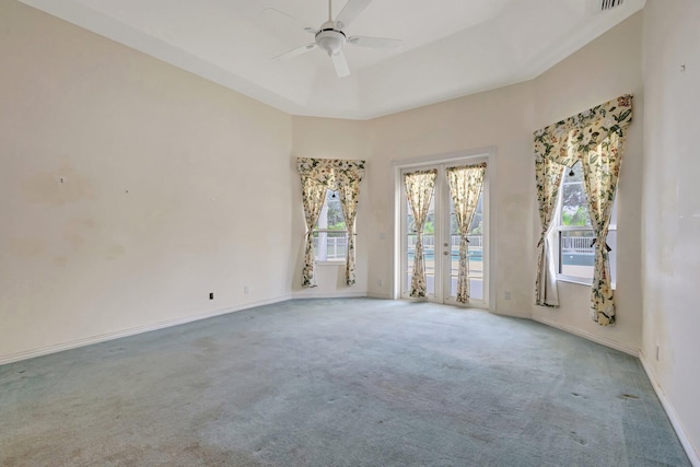 carpeted empty room featuring ceiling fan, baseboards, and french doors