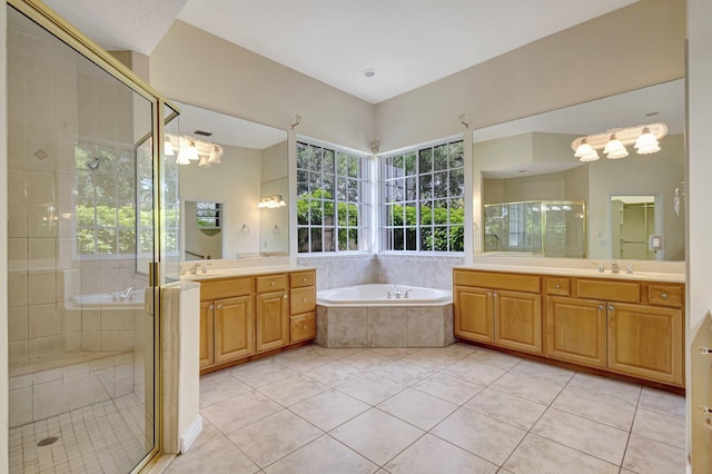 full bath featuring a garden tub, tile patterned floors, a stall shower, and two vanities