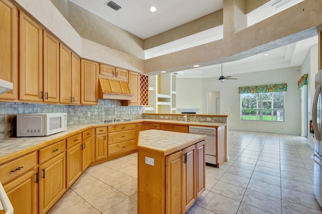 kitchen featuring white appliances, premium range hood, a peninsula, light tile patterned floors, and tasteful backsplash