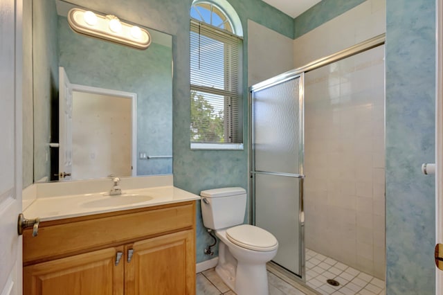 bathroom featuring tile patterned flooring, a stall shower, toilet, and vanity