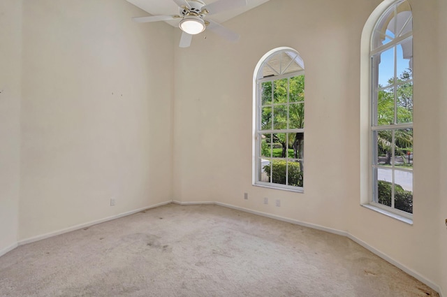 carpeted empty room featuring healthy amount of natural light, baseboards, and ceiling fan