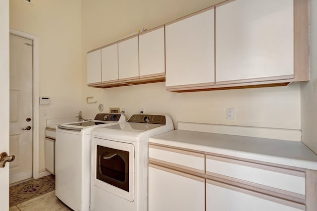 laundry area with cabinet space, washer and clothes dryer, and light tile patterned floors