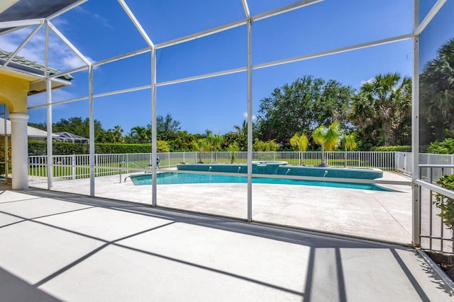 view of swimming pool with a patio area, fence, and glass enclosure