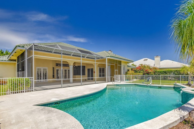 view of swimming pool with a patio area, fence, and french doors