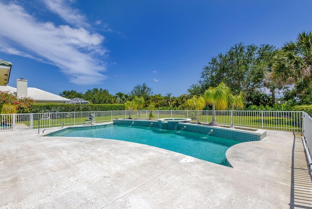 view of pool featuring a patio, fence, and a pool with connected hot tub