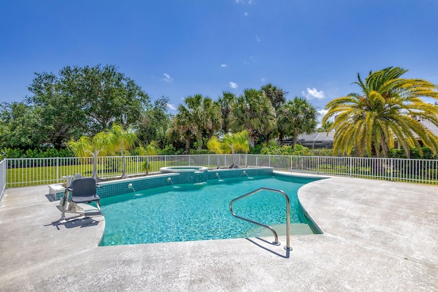 view of pool with fence, a patio, and a pool with connected hot tub