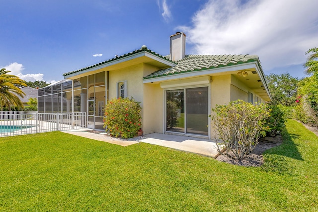 back of property with stucco siding, a chimney, and a patio