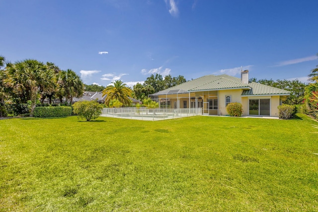 back of house with a chimney, a tiled roof, a lanai, and stucco siding