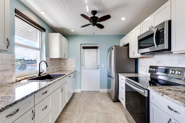 1 S Lakeside Dr Unit C1, Lake Worth Beach, FL 33460 - kitchen featuring a ceiling fan, white cabinets, tasteful backsplash, a sink, and stainless steel appliances