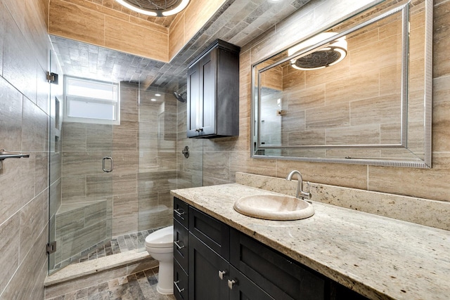 1 S Lakeside Dr Unit C1, Lake Worth Beach, FL 33460 - full bath with vanity, toilet, tile walls, tasteful backsplash, and a stall shower