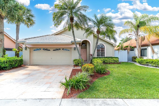 mediterranean / spanish home featuring stucco siding, an attached garage, concrete driveway, and a tile roof