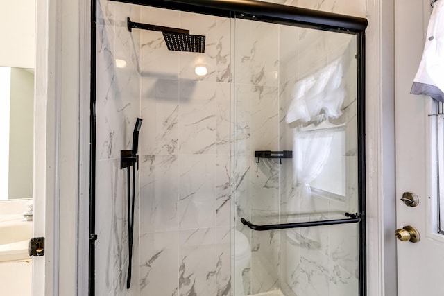 bathroom featuring a marble finish shower
