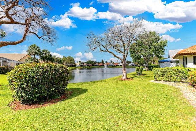 view of grassy yard with a water view and a residential view