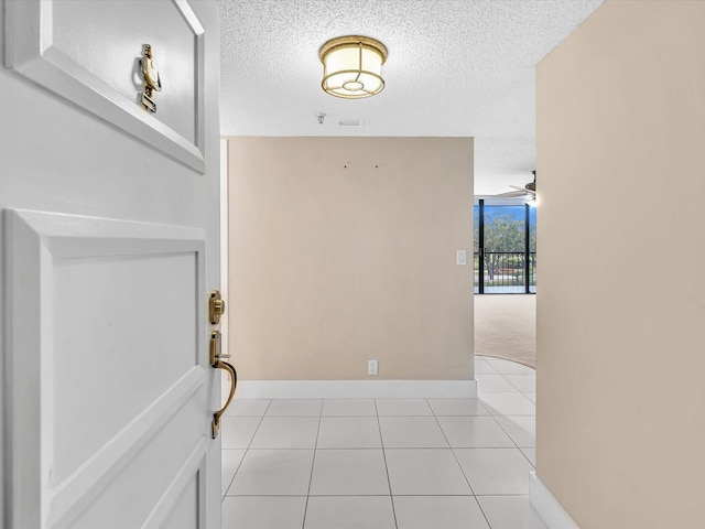 20110 Boca W Dr Unit 232, Boca Raton, FL 33434 - foyer with a textured ceiling, baseboards, a ceiling fan, and light tile patterned floors