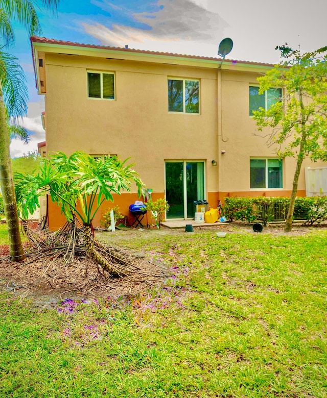 3500 Briar Bay Blvd Unit 106, West Palm Beach, FL 33411 - back of house with stucco siding and a lawn