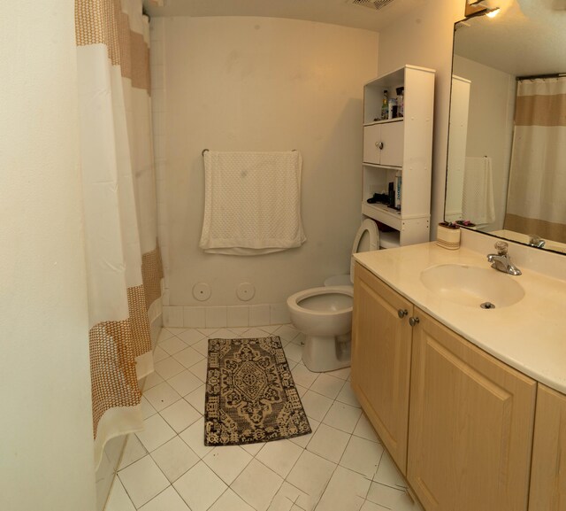 bathroom featuring toilet, tile patterned floors, vanity, and a shower with shower curtain