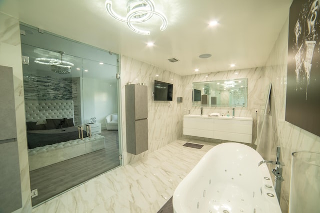 4941 SW 150th Ter, Miramar, FL 33027 - bathroom with a soaking tub, double vanity, tile walls, recessed lighting, and marble finish floors