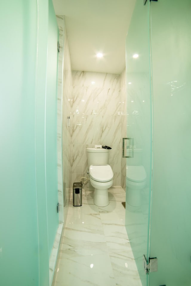 4941 SW 150th Ter, Miramar, FL 33027 - bathroom featuring toilet, marble tiled floors, and tile walls