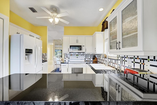 kitchen with glass insert cabinets, a sink, white cabinetry, ceiling fan, and white appliances