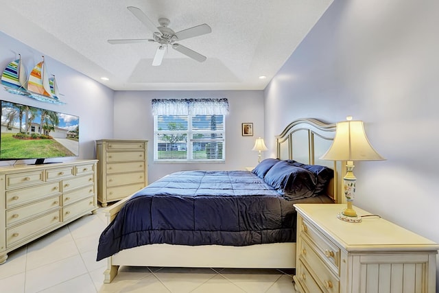 bedroom with a textured ceiling, light tile patterned flooring, and a ceiling fan