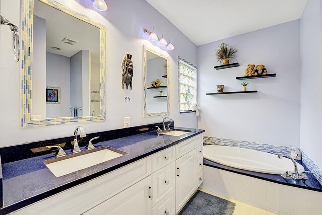 bathroom with double vanity, a garden tub, tile patterned floors, and a sink