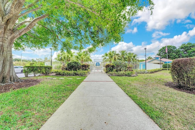 surrounding community with a lawn, a fenced front yard, and a gate
