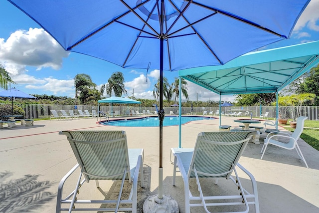 pool with a patio and fence