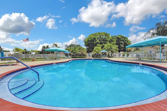 pool with a patio and fence