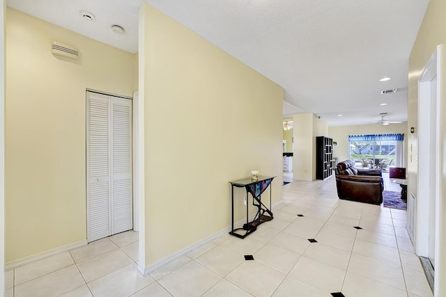 hall featuring visible vents, baseboards, light tile patterned flooring, and recessed lighting
