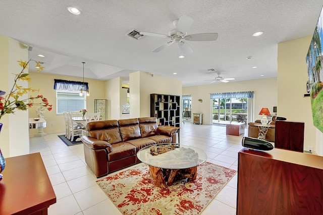 living room with ceiling fan, light tile patterned flooring, and plenty of natural light