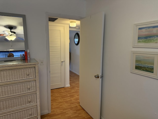 corridor featuring light wood-style flooring and visible vents