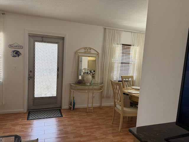 entrance foyer with baseboards, light wood-type flooring, and plenty of natural light
