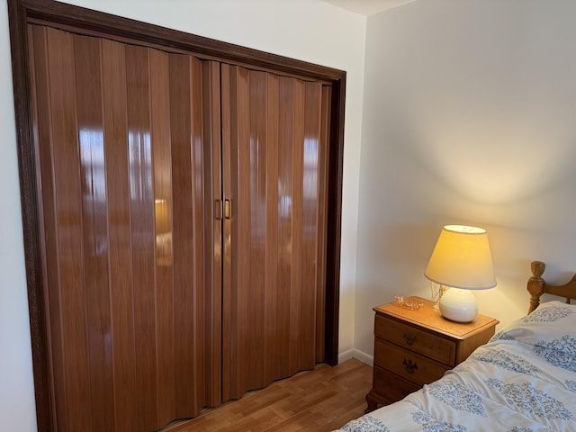 bedroom with baseboards and light wood finished floors
