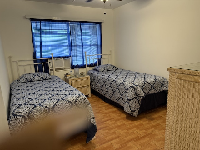 bedroom featuring cooling unit and wood finished floors