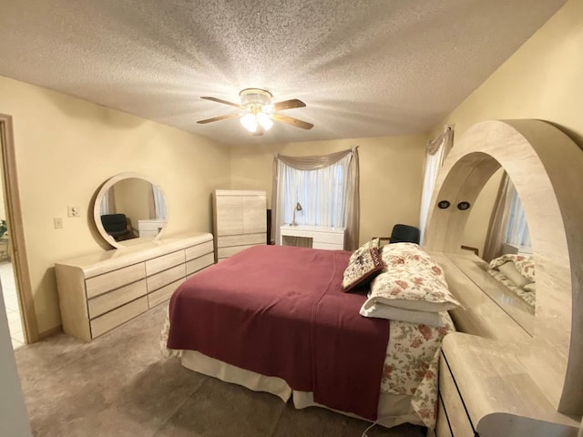 carpeted bedroom featuring a textured ceiling and ceiling fan