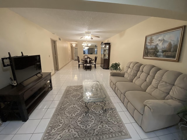 living area with light tile patterned flooring, ceiling fan, and a textured ceiling