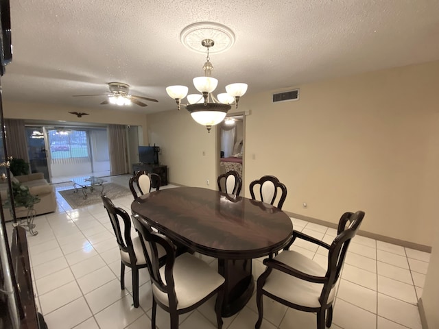dining space with light tile patterned floors, a textured ceiling, ceiling fan, and a chandelier