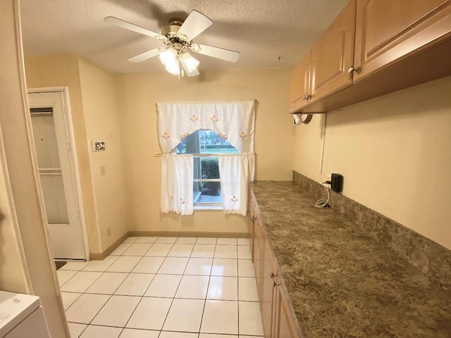 kitchen featuring a textured ceiling, a ceiling fan, light tile patterned floors, and baseboards