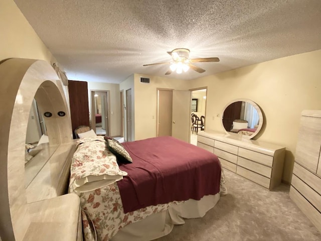 carpeted bedroom with a textured ceiling and a ceiling fan