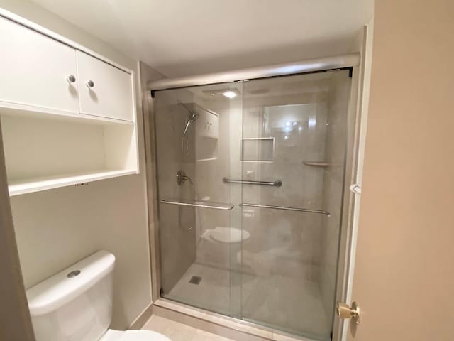 bathroom with toilet and a stall shower