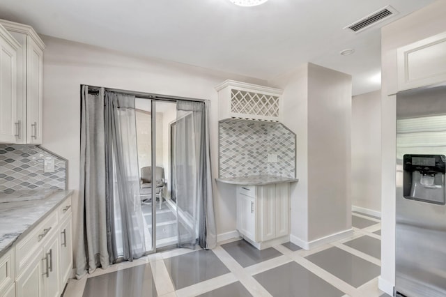 4875 Hawkwood Rd Unit B, Boynton Beach, FL 33436 - interior space with stainless steel refrigerator with ice dispenser, white cabinetry, visible vents, light stone countertops, and backsplash