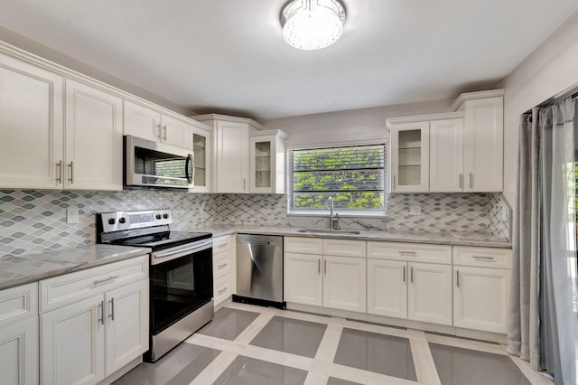 4875 Hawkwood Rd Unit B, Boynton Beach, FL 33436 - kitchen with a sink, white cabinetry, light stone countertops, appliances with stainless steel finishes, and tasteful backsplash